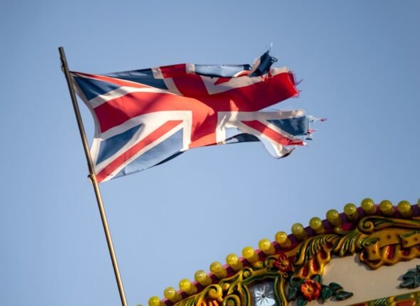 a british flag flying on top of a carnival ride