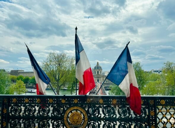 a fence with two flags on top of it