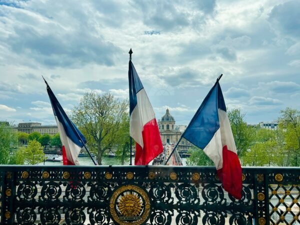 a fence with two flags on top of it